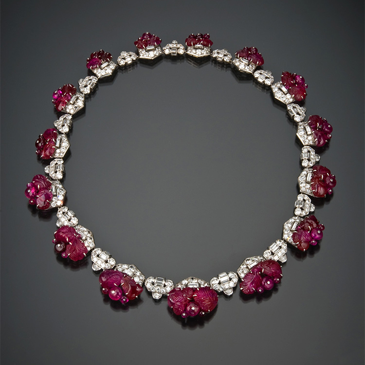 Art Deco carved ruby and diamond necklace by Mauboussin circa 1930. The ruby beads are secured to the frame by white metal posts capped with a tiny diamond.